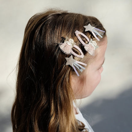 Girl with fairy hair clips in her hair against a neutral background
