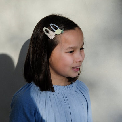 Young girl with a decorative lemon blossom hair clip on a neutral background