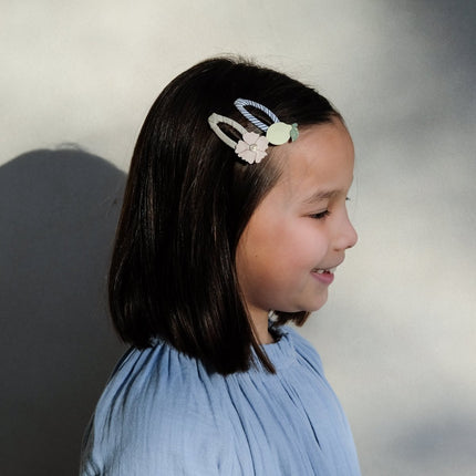 Young girl with a decorative hair clip on a plain background