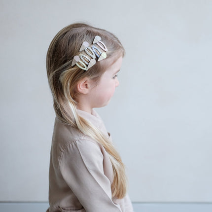 Young girl with a decorative hair clip on a plain background