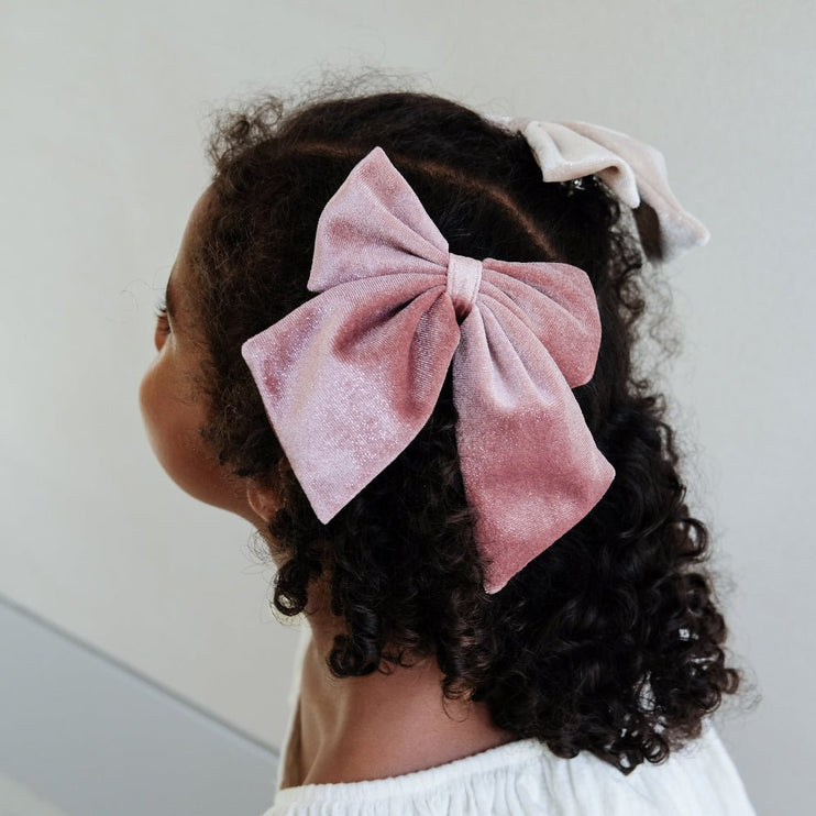 Child with pink velvet hair bow 