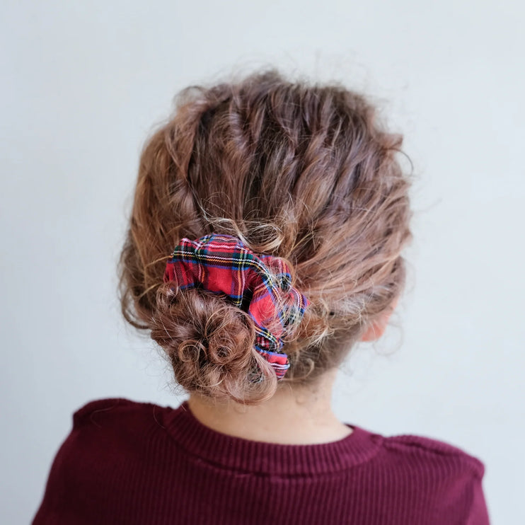 Person with plaid scrunchie in a bun against a plain background