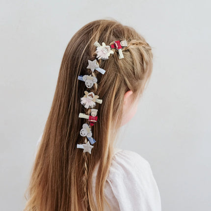 Person with decorative hair clips in a braid on a plain background