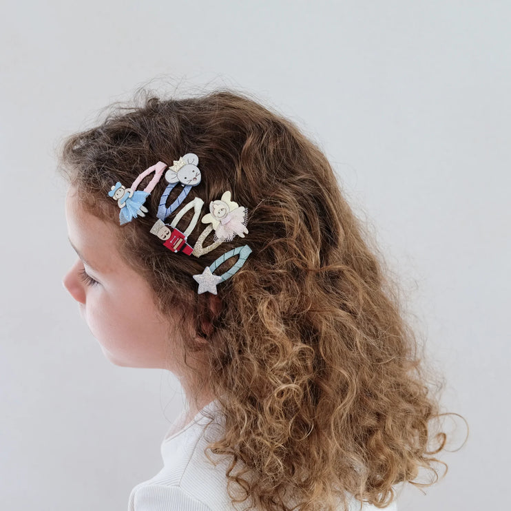 Child with curly hair wearing nutcrackers mini clic clacs