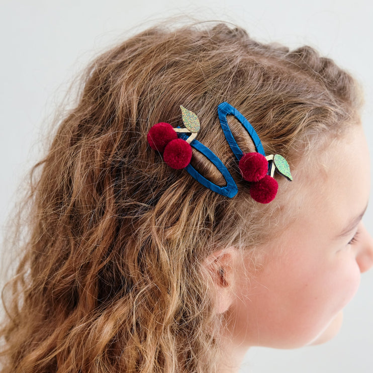 A young girl with cherry hair clip