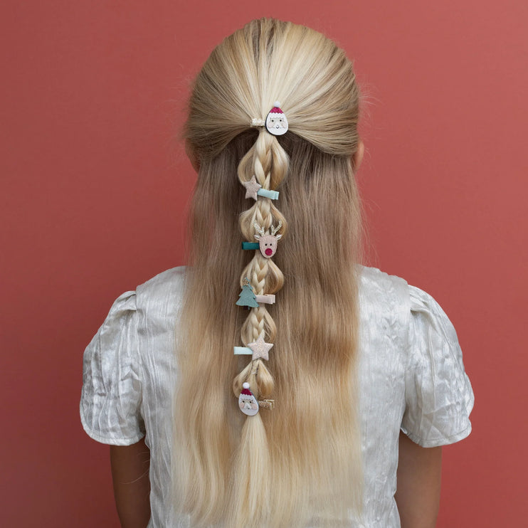 Kid with long blonde hair styled in braids with decorative hair clips