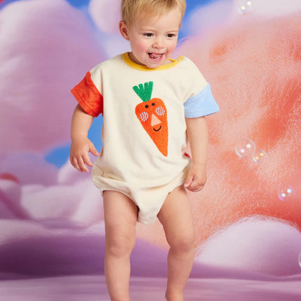 a baby wearing a colorful short sleeve  body suit with carrot patch in front