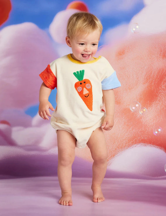 a baby wearing a colorful short sleeve  body suit with carrot patch in front