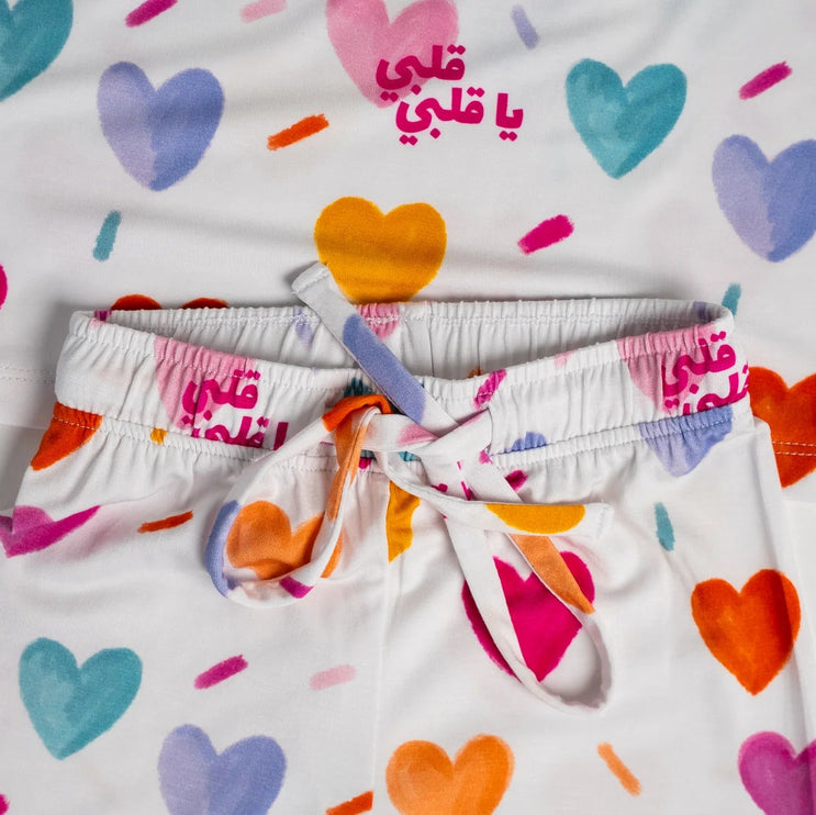 Children's pajama set with colorful heart patterns on a white background