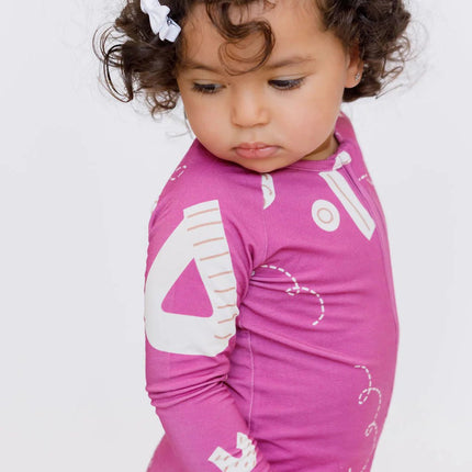 Child wearing Arqam onesie with white patterns.