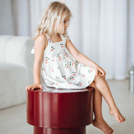 Young girl in a white dress with cherry print 