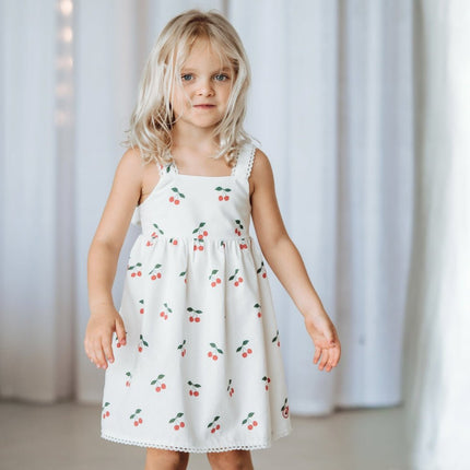 kid wearing white dress with cherry pop print