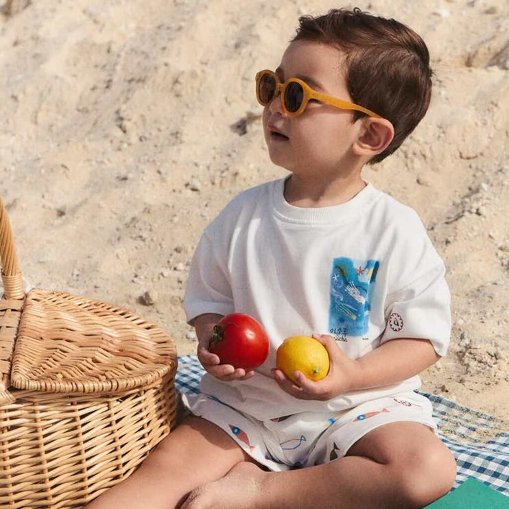 a child wearing a white t-shirt with small details in front