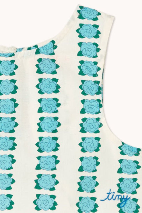 Off-white sleeveless top with blue flower pattern and 'tiny' print