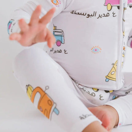 Baby wearing a Bosta romper with colorful bus designs.