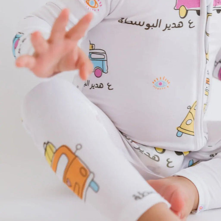 Baby wearing a Bosta romper with colorful bus designs.
