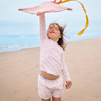 Playful baby girl wearing Cream with butterflies print longsleeves top and matching swim short