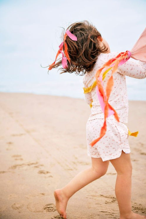 Playful baby girl wearing Cream with butterflies print longsleeves top and matching swim short