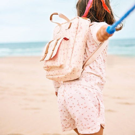 Girl wearing matching cream with butterfly print long-sleeve top and shorts with matching backpack.