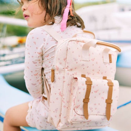Girl wearing matching cream with butterfly print long-sleeve top and shorts with matching backpack.