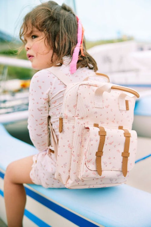 Girl wearing matching cream with butterfly print long-sleeve top and shorts with matching backpack.