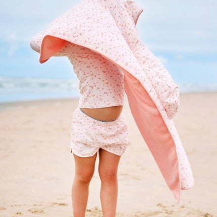 Girl wearing matching cream with butterflies prints long-sleeve top and shorts with matching poncho.