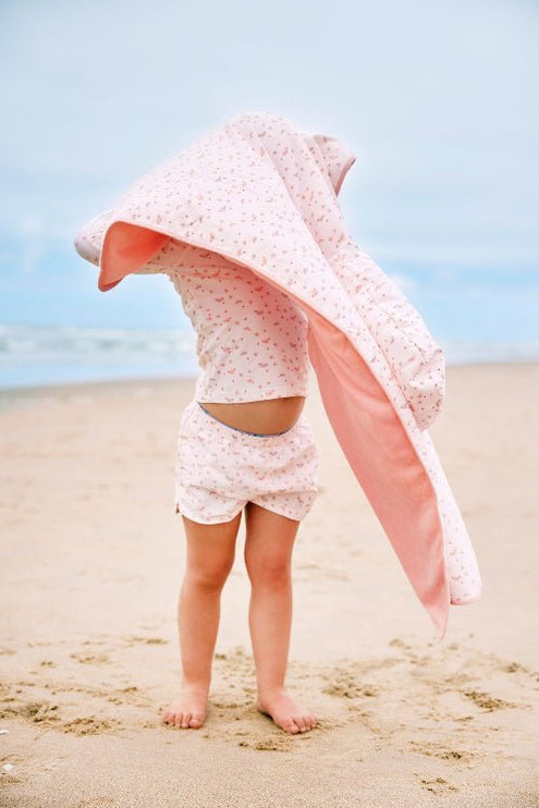 Girl wearing matching cream with butterflies prints long-sleeve top and shorts with matching poncho.