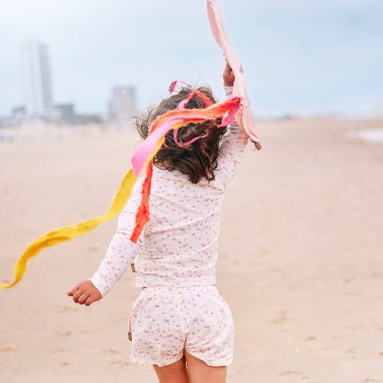 Playful baby girl wearing Cream with butterflies print longsleeves top and matching swim short