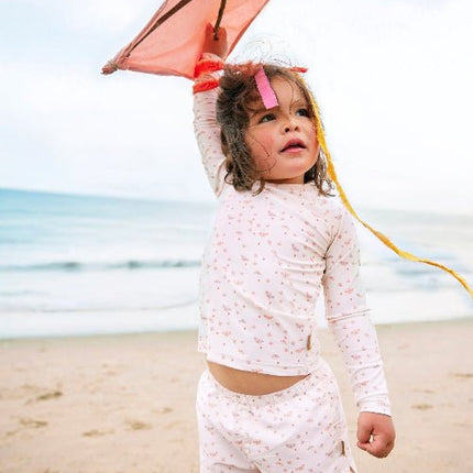 Playful baby girl wearing Cream with butterflies print longsleeves top and matching swim short