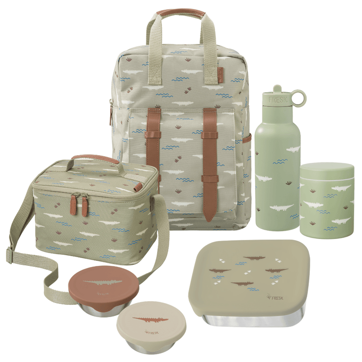 A coordinated school or picnic gear set on a white background, including a large backpack, a cooler bag, a water bottle, a lunch box with lid, a thermos food jar, and two snack boxes. The items are printed with a small crocodile pattern in muted blue, brown, and white on a light sage/gray-green base, with tan straps and trim.