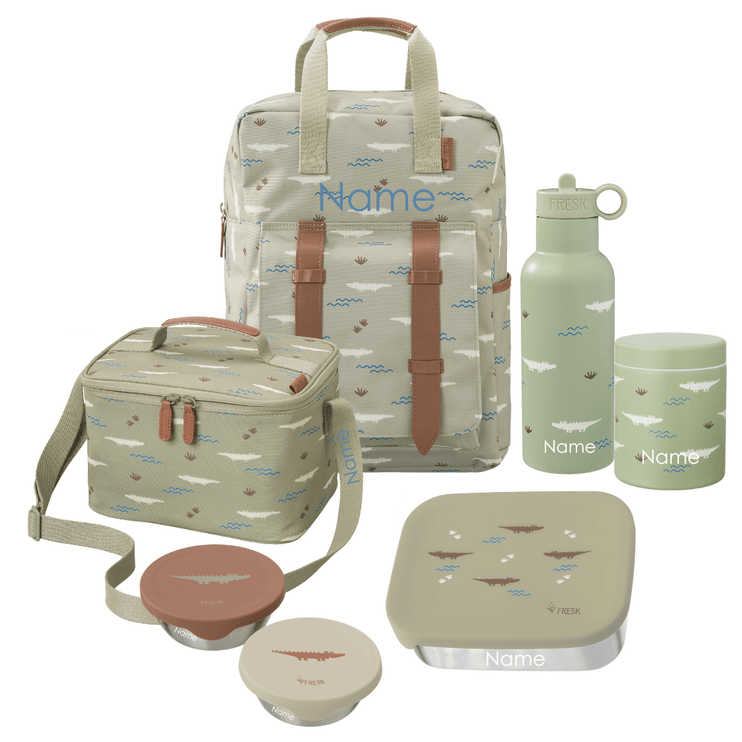 A coordinated school or picnic gear set on a white background, including a large backpack, a cooler bag, a water bottle, a lunch box with lid, a thermos food jar, and two snack boxes. The items are printed with a small crocodile pattern in muted blue, brown, and white on a light sage/gray-green base, with tan straps and trim. All Items can be personalized
