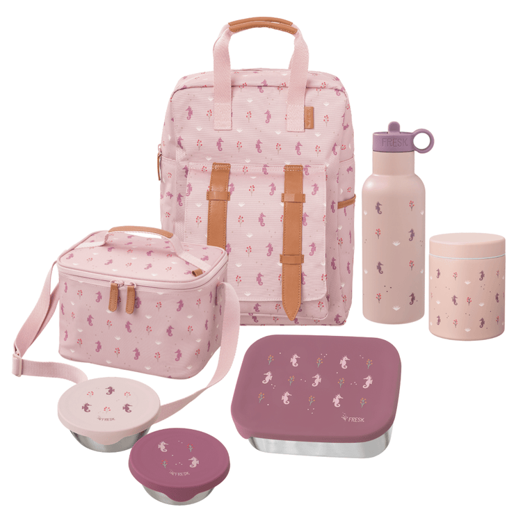 A coordinated school or picnic gear set in soft pink tones, including a backpack, insulated lunch bag, water bottle, cylindrical container, two bowls, and a square lunch box, all with a repeating seahorse print