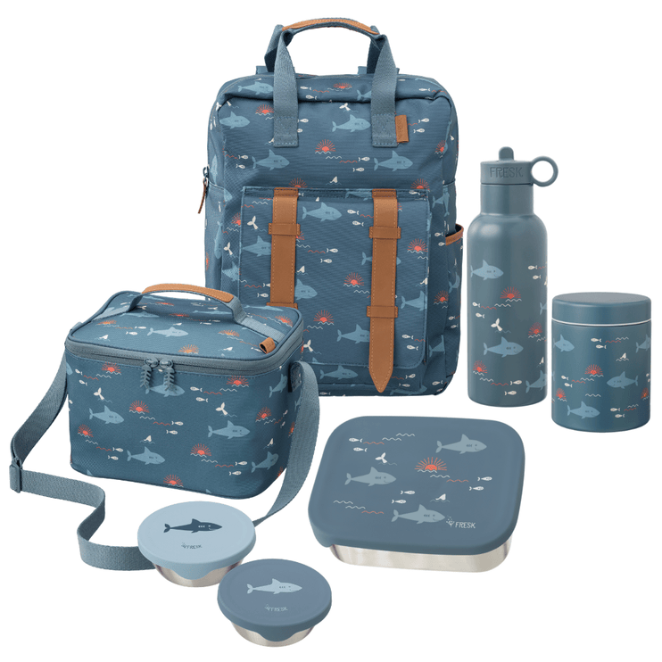 A coordinated school or picnic gear set in a muted blue-gray color with an allover shark print, including a large backpack, a cooler bag, a water bottle, a lunch box with lid, a thermos food jar, and two snack boxes.