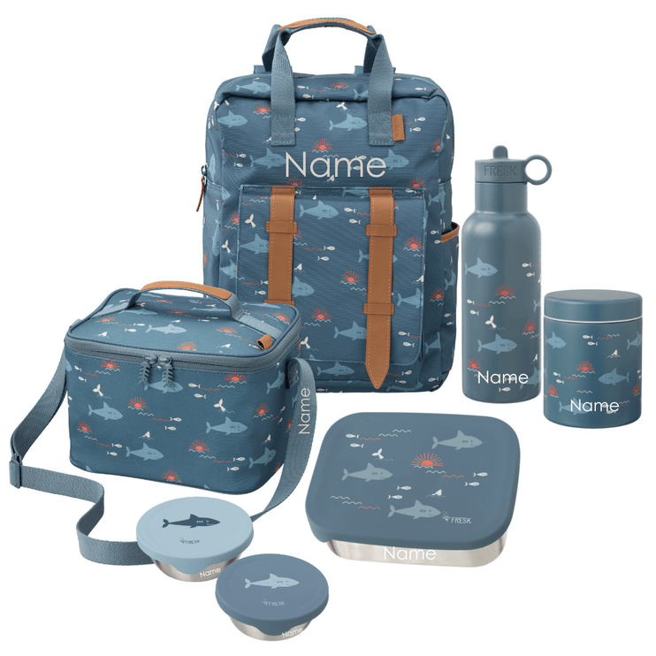 A coordinated school lunch set with an ocean-shark print. The set includes a large backpack, a cooler bag, a water bottle, a lunch box with lid, a thermos food jar, and two snack boxes. All items can be personalized