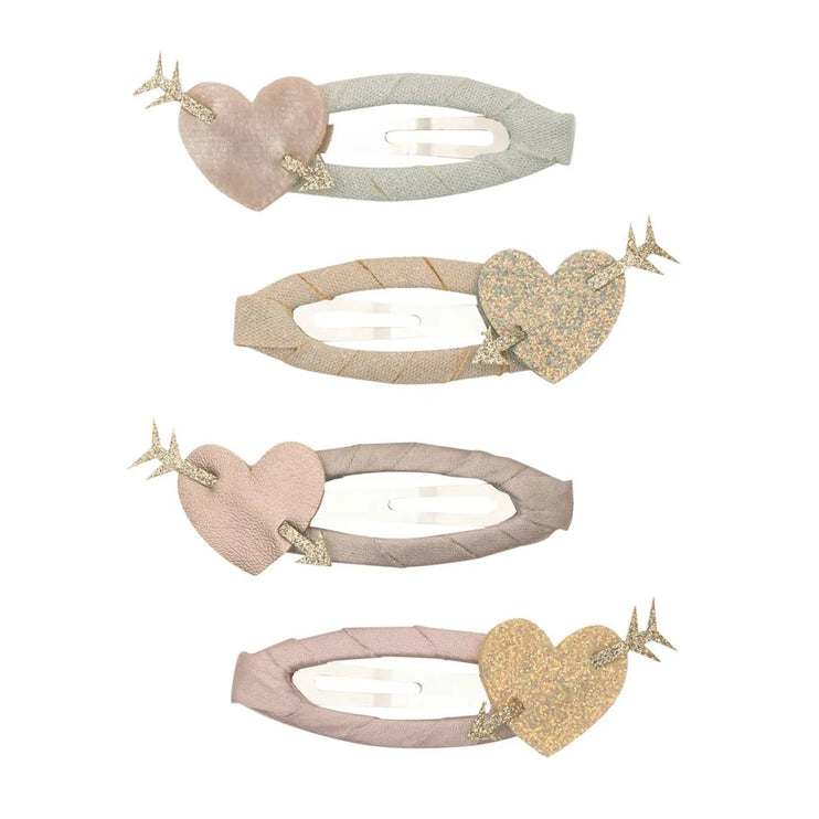 Four hair claw clips, each featuring a heart-shaped embellishment and a small gold bird accent. The clips come in soft pastel shades including blush pink, light sage green, champagne beige, and dusty mauve, with textured fabric and glittery heart details.