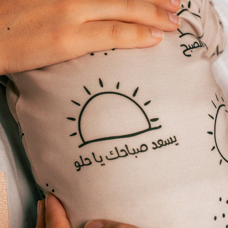 Sobh onesie Arabic text and sun designs.