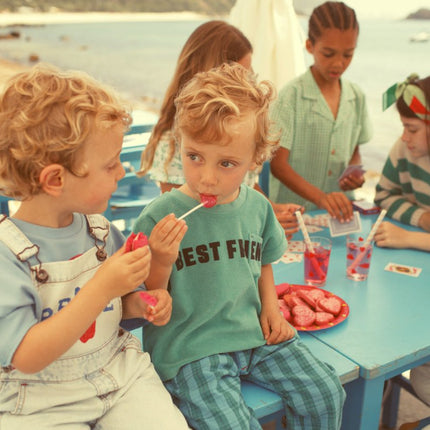 Boy wearing washed light blue dungaress demin with peace print