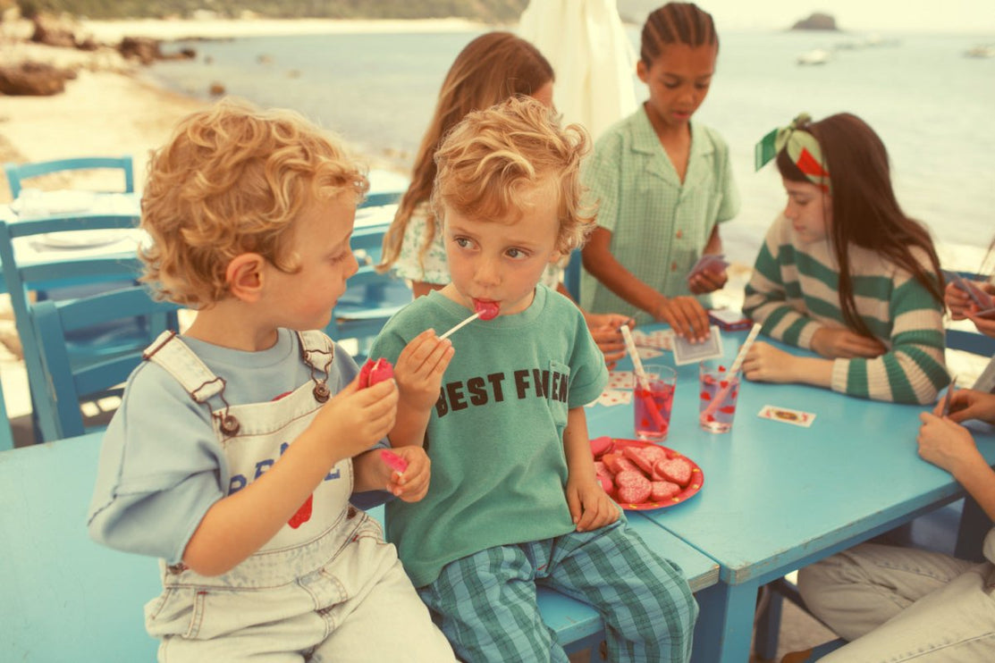 Boy wearing washed light blue dungaress demin with peace print