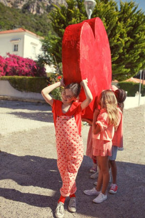 Girl wearing Pink Dungaress with red hearts all over