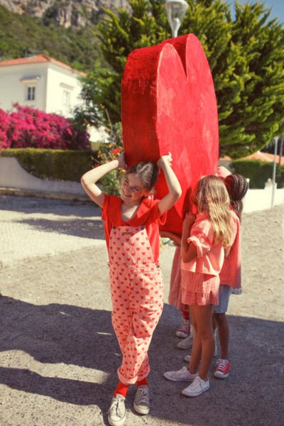 Girl wearing Pink Dungaress with red hearts all over