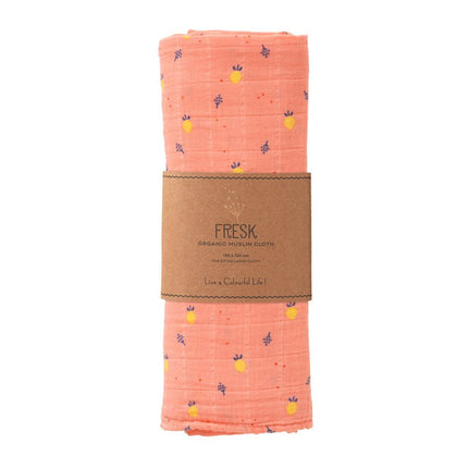 Folded peach organic swaddle summer fruit patterned with a brown label on a white background
