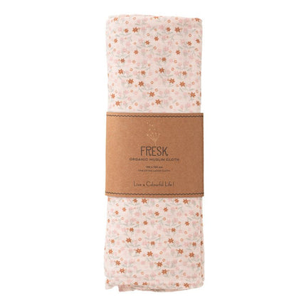Folded organic swaddle with floral pattern and brown label on a white background