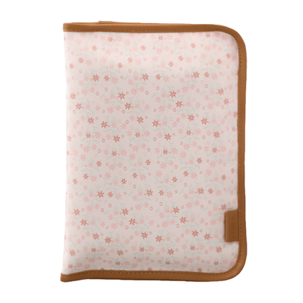 Folded cream changing mat with a garden flowers pattern and brown edges.
