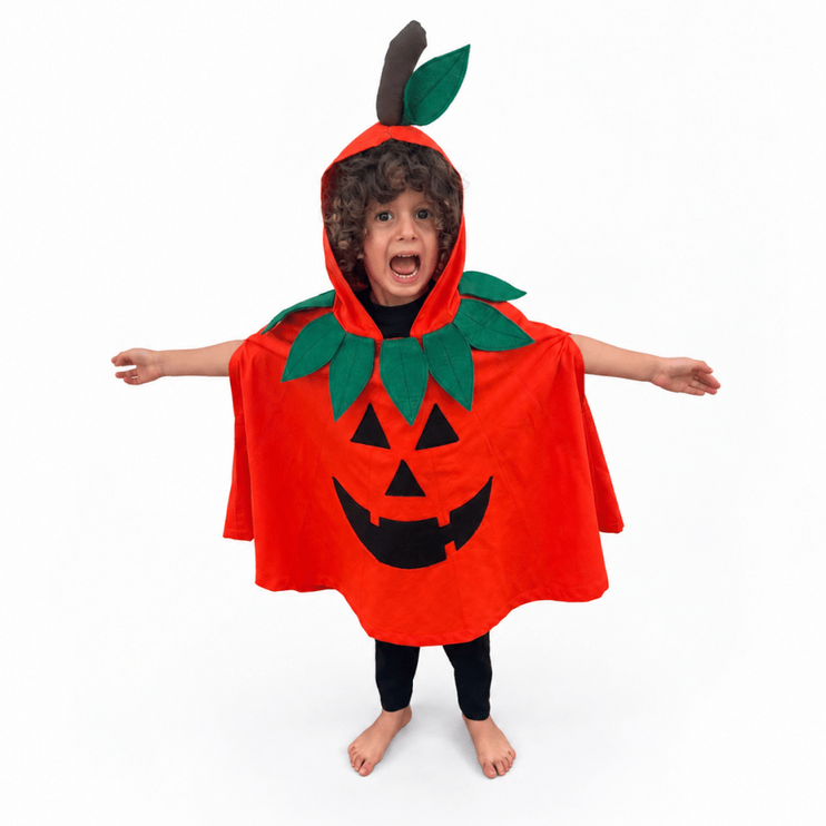 A child wearing a bright orange pumpkin costume cape with green leaves and a black jack-o'-lantern face, standing barefoot against a plain white background.