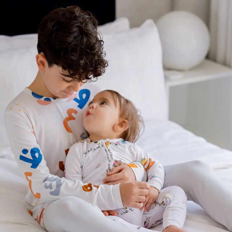 Siblings wearing matching Huroof long sleeve pajama