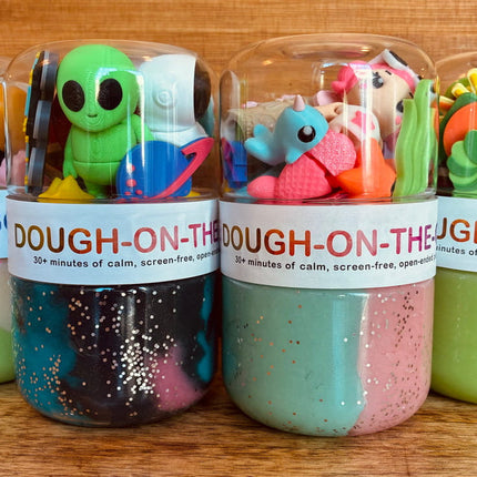 plastic jars filled with colorful dough-like play products and topped with cartoon figures