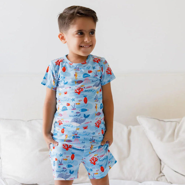 A child wearing Kebr l Baher pajama with ocean theme design.