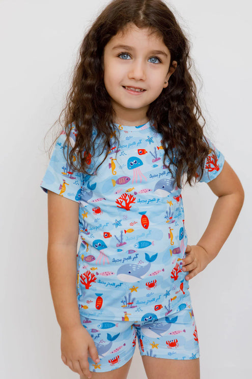 Child wearing a Kebr l Baher pajama set with ocean-themed design 