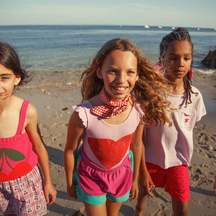 Girl wearing pink knitted top with straps and Cherry Print