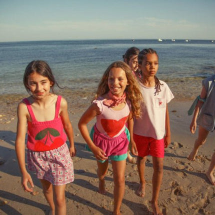 Girl wearing pink knitted top with straps and Cherry Print